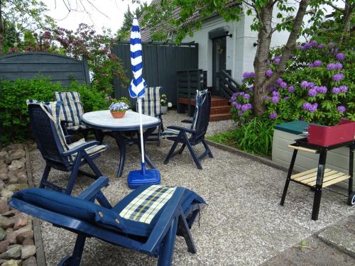 a patio with chairs and a table with an umbrella at Hofwohnung Steinbergkirche in Steinbergkirche
