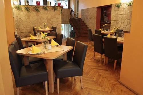 a restaurant with wooden tables and black chairs at Pensjonat Beata in Polanica-Zdrój