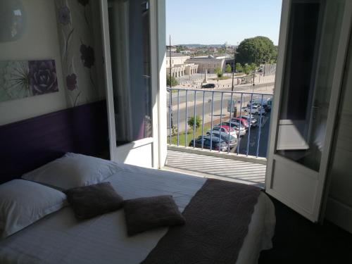 a bedroom with a bed and a view of a parking lot at Hotel d'Orléans in Angoulême