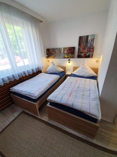 a bedroom with two beds and a window at FewoFaubelCentro 42 & 54 & 62 m2 in Oberhausen