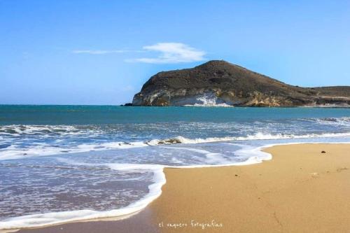 a sandy beach with a mountain in the background at ZARATUSTRA. Rodalquilar CENTRO. GRAN terra. WIFI in Rodalquilar
