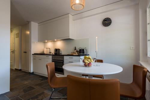 a kitchen with a white table and chairs at Montela Hotel & Resort - Casa Antares in Saas-Grund