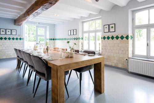 a large dining room with a wooden table and chairs at Fletcher Hotel Château De Raay in Baarlo