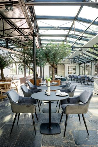 a patio with a table and chairs in a building at Fletcher Hotel Château De Raay in Baarlo