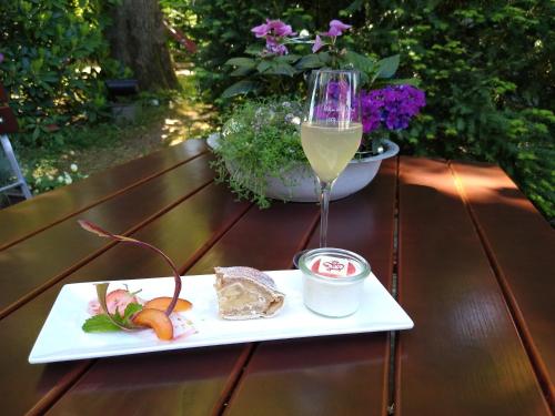 a glass of wine and a plate of food on a table at Hotel-Restaurant Haus Berkenbaum in Kierspe