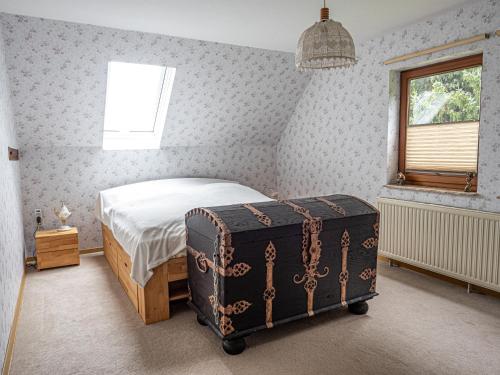 a bedroom with a bed with a trunk next to a window at Ferienhaus Waldidyll in Lemgo