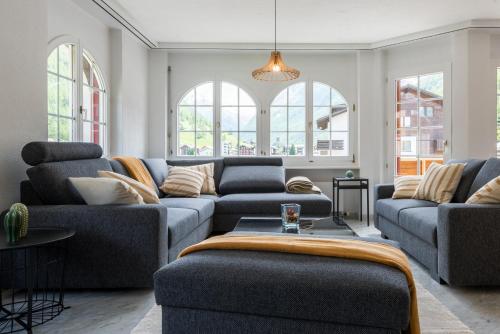 a living room with two couches and a table at Montela Hotel & Resort - Casa Antares in Saas-Grund