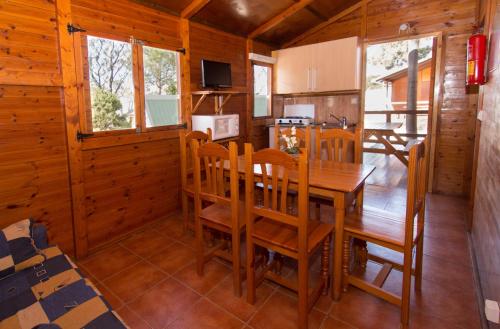 a kitchen and dining room with a wooden table and chairs at Complejo Turístico & Camping Cabopino in Marbella