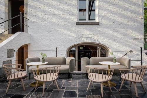 a patio with tables and chairs in front of a building at Fletcher Hotel Château De Raay in Baarlo