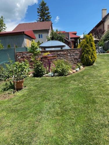 a yard with a brick wall and a yard with plants at Holiday Home V Kolte in Kolta
