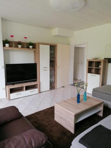 Una sala de estar con televisión y una mesa de café. en FEWO-ATLANTA Reinhardshausen, en Reinhardshausen