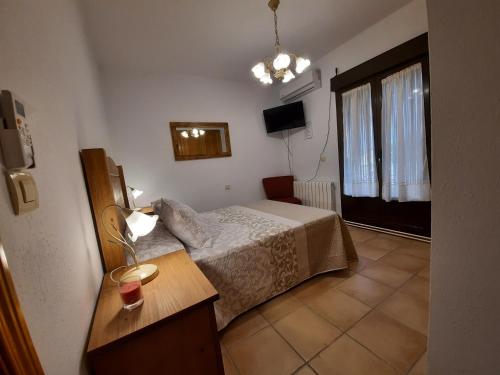 a small bedroom with a bed and a window at La Dama del Quijote in El Toboso