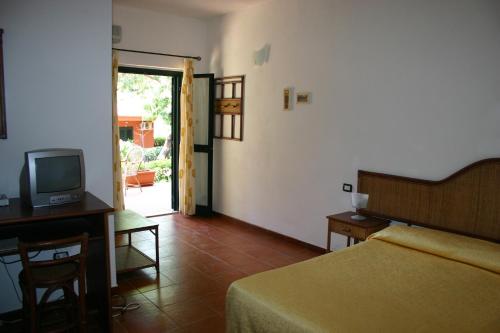 a bedroom with a bed and a television and a table at casa vacanze marzano in Tropea