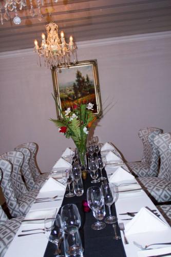 a table with wine glasses and a vase of flowers at Classique Grace Boutique Hotel in Johannesburg