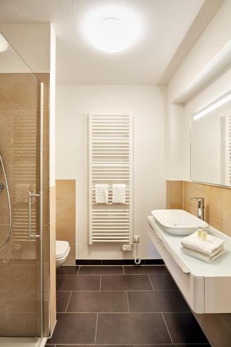a bathroom with a sink and a toilet and a shower at Aparthotel Parkallee in Mainz