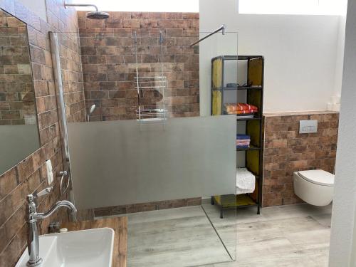 a bathroom with a sink and a glass shower at Gästehaus Schewe in Ahnsen