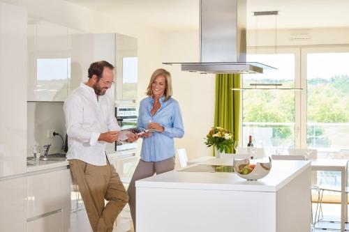 a man and a woman standing in a kitchen at Aparthotel Parkallee in Mainz