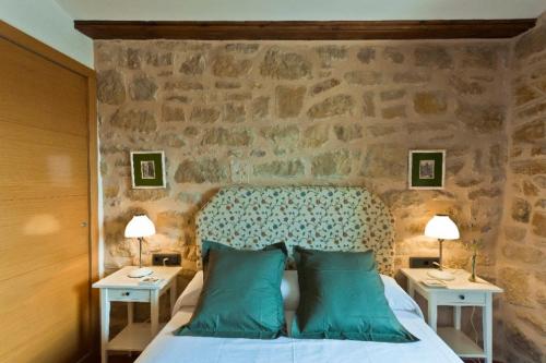 a bedroom with a bed with a stone wall at Casa Carmela in Calaceite