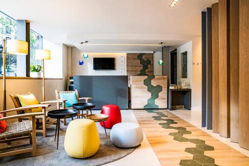 a living room with tables and chairs and a kitchen at ibis Styles Barcelona Centre in Barcelona