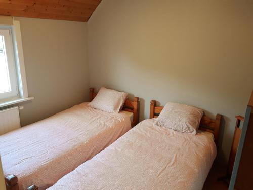 two beds in a small room with a window at Vakantiewoning FINE FLEUR in Bruges