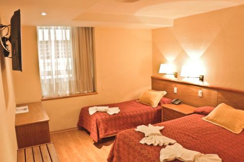 a hotel room with two beds with towels on them at Hotel Felipe II in Cordoba