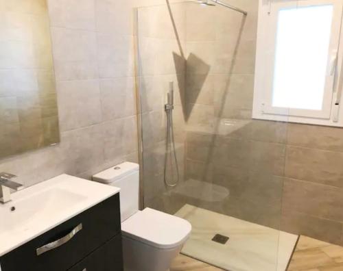y baño con ducha, aseo y lavamanos. en Villa Serena - amazing villa with private pool, en Cómpeta