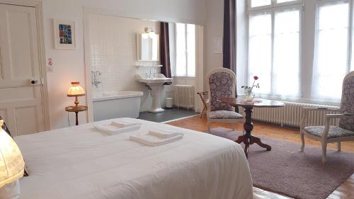 una camera con letto, lavandino e tavolo di La Maison Serrurier - Chambres d’hôtes a Morlaix