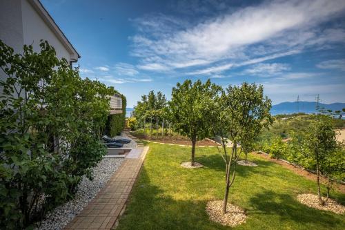 a garden with two trees in the grass at TERRA MAGICA DELUXE Apartment Or Room with Private Parking, Terrace and Sea View in Rijeka