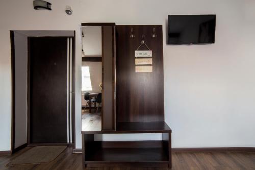 Zimmer mit einer Tür, einem TV und einem Tisch in der Unterkunft Апартаменти з сучасним ремонтом в центрі (площа Митна) in Lwiw