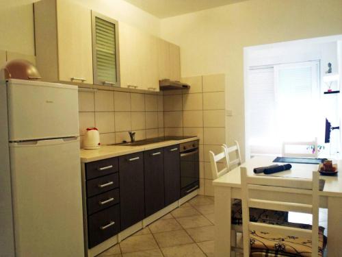 La cuisine est équipée d'un réfrigérateur blanc et d'un évier. dans l'établissement Apartment Ella, à Split
