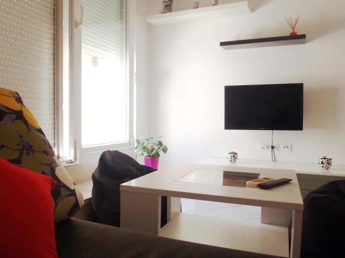 a living room with a couch and a table and a tv at Apartment Ella in Split