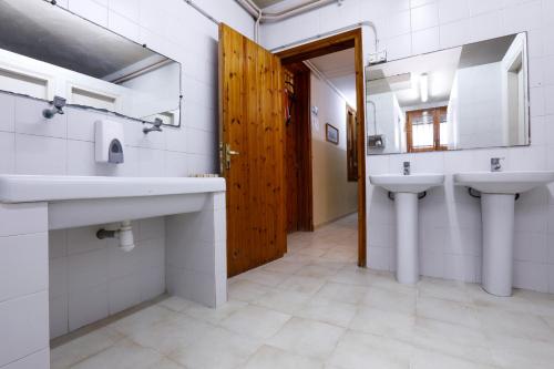 baño con 2 lavabos y puerta de madera en Casa Alberg 4 Vents, en Os de Balaguer