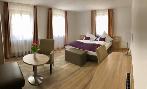 Habitación de hotel con cama, mesa y sillas en A Lotus Hotel, en Böblingen