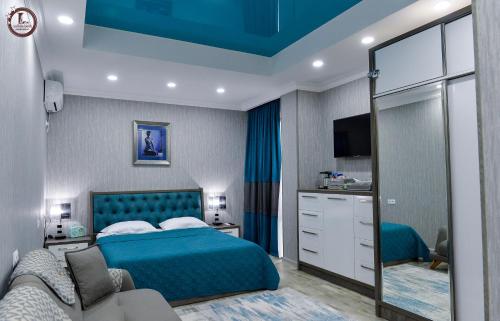 a bedroom with a blue bed and a couch at Tsereteli Inn in Kutaisi