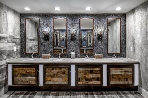 un bagno con tre lavandini e quattro specchi di Crowne Plaza Resort Asheville by IHG ad Asheville
