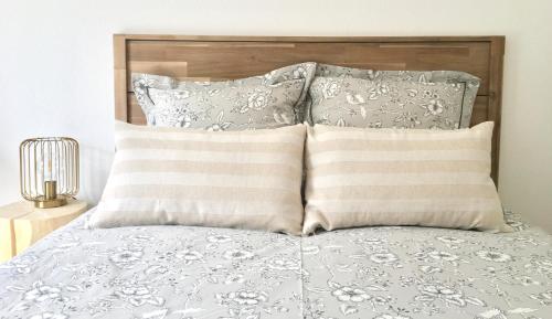 a bed with two pillows and a wooden headboard at Studio en face Hopital Nord avec terrasse in Saint-Priest-en-Jarez