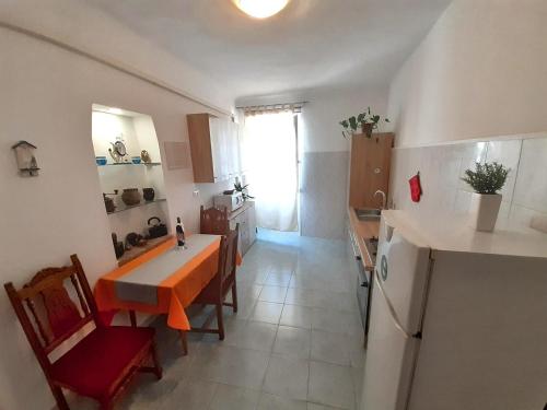 una pequeña cocina con mesa y nevera en Guest House Barocco en Rovinj