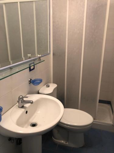 un bagno con lavandino, WC e specchio di TAORMINA CENTER APARTMENT with sea view a Taormina