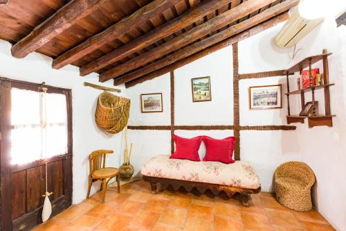 um quarto com uma cama com almofadas vermelhas em La Casa de los Soportales em Chinchón