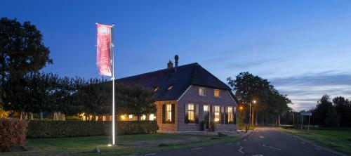a house with a sign on the side of a street at De Veurdeale in Havelte