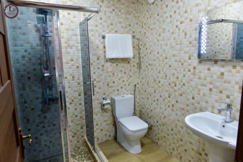 a bathroom with a shower and a toilet and a sink at Tsereteli Inn in Kutaisi