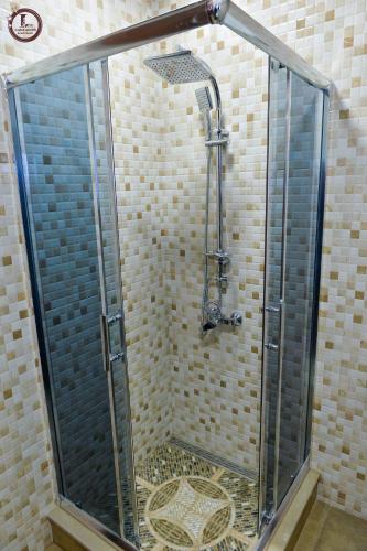 a shower with a glass door in a bathroom at Tsereteli Inn in Kutaisi