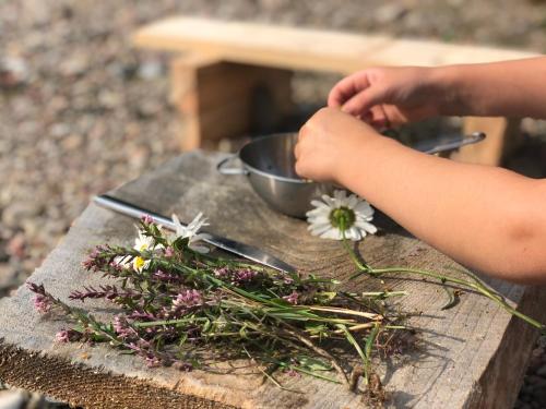 a child is arranging flowers on a wooden table at Jūrvingė in Žadvainai