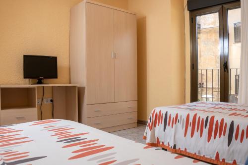 A bed or beds in a room at Hostal El Trillero