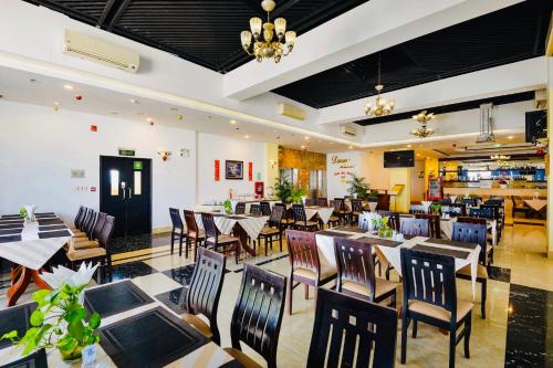 Happy Life Hotel District 7 Gần SECC في مدينة هوشي منه: مطعم فيه طاولات وكراسي في الغرفة