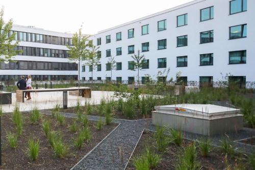 a garden in front of a building at Holiday Inn Munich - Leuchtenbergring by IHG in Munich