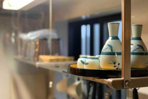 two vases sitting on a shelf in a room at TRAD GUEST HOUSE KYOTO Kyomachiya in Kyoto