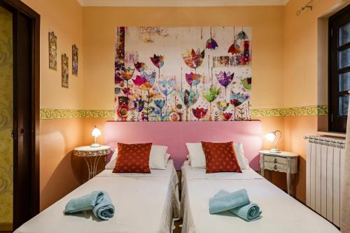 zwei Betten in einem Zimmer mit einem Gemälde an der Wand in der Unterkunft Villa Rubino in Catania