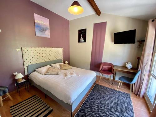 Dormitorio con cama, escritorio y TV en Les Barongères, en Farges-lès-Chalon
