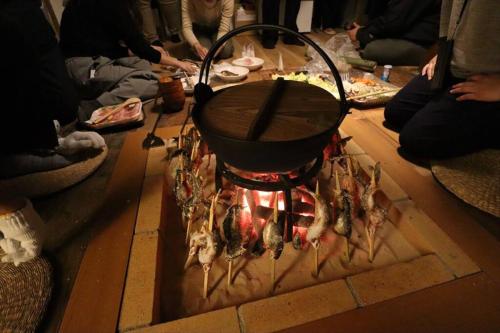 un pot assis au-dessus d'une cuisinière avec de la nourriture dans l'établissement 炉之宿 淀川, à Osaka